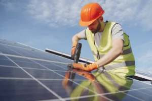 Technician installing solar panels on a commercial rooftop using power tools
