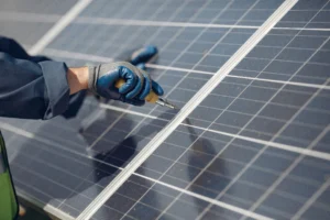 Technician performing solar panel installation and tightening components on a rooftop solar system
