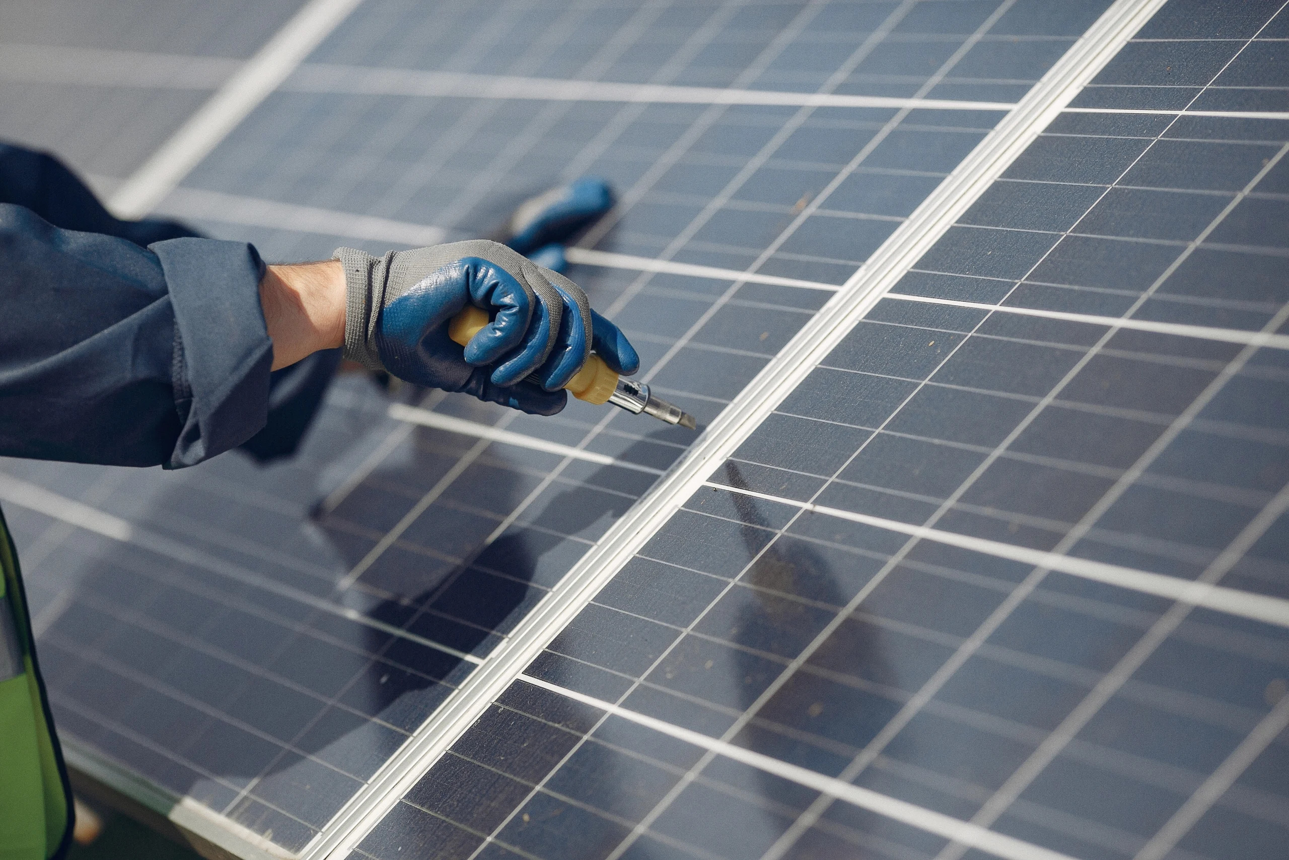 Technician performing solar panel installation and tightening components on a rooftop solar system