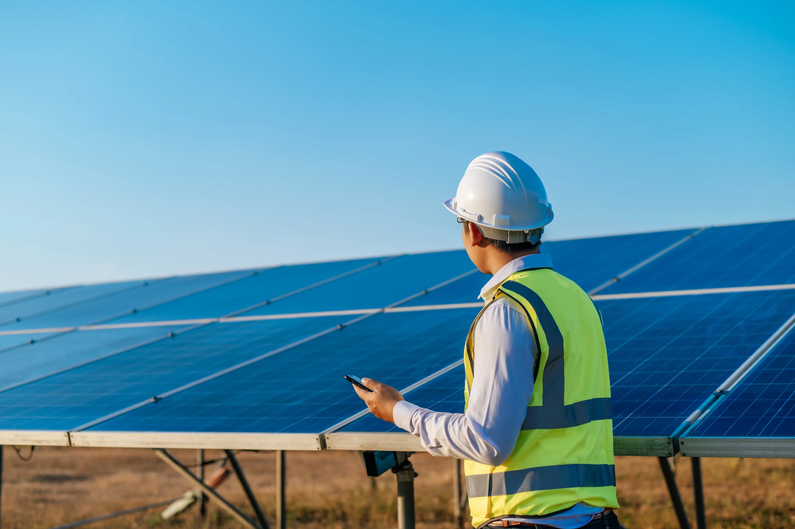 Technician checking a commercial solar system installation outdoors